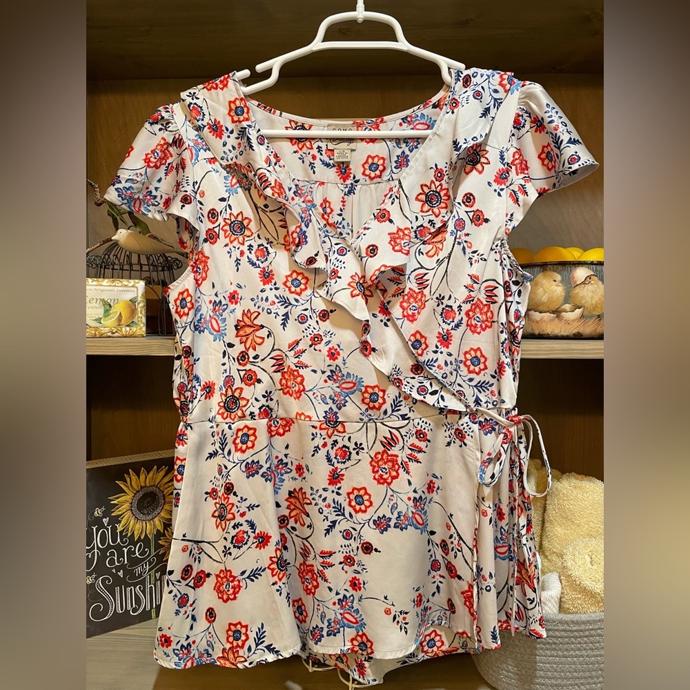 Fun floral top with cap sleeves. Mock wrap around look.
